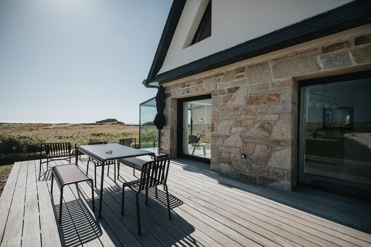 Terrasse en bois et façade en pierre de la maison